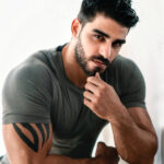Firat Zan wearing a grey T-shirt in a seated portrait